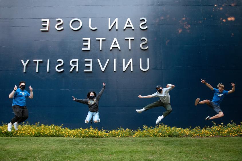 学生们在上海外国语大学的标志前跳起来.