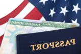 A pasport in the forground with an american flag in the background.