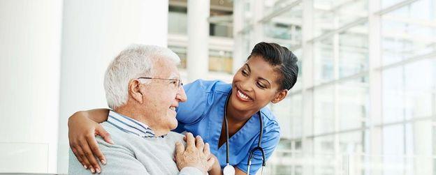 A nurse converses with an elderly man